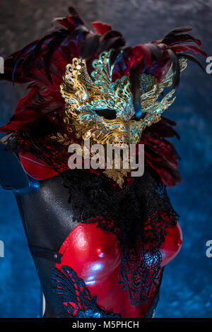 Partei in venezianischem Rot, Maske und roten Korsett mit Stücken von Gold und schwarze Spitze Stoffen auf Metall Schild. Handgefertigte piea für Partys oder Kostüm Sitzungen Stockfoto