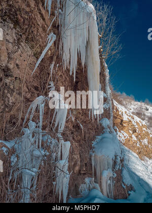 Riesige Eisblöcke hängen von der Klippe. Die Schönheit der Wilden. Stockfoto