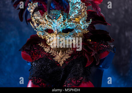 Dekoration in venezianischem Rot, Maske und roten Korsett mit Stücken von Gold und schwarze Spitze Stoffen auf Metall Schild. Handgefertigte piea für Partys oder Kostüm mee Stockfoto