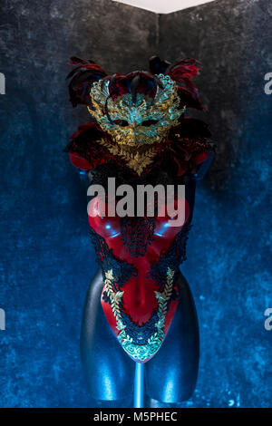 Maskerade Partei in venezianischem Rot, Maske und roten Korsett mit Stücken von Gold und schwarze Spitze Stoffen auf Metall Schild. Handgefertigte piea für Partys oder costu Stockfoto