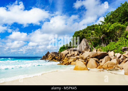 Tropischer Strand mit Granitfelsen, Palmen, weißer Sand, türkises Wasser. das Paradies auf den Seychellen Stockfoto