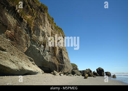 Eine Klippe bei Ebbe auf dem West Coast Beach, South Island, Neuseeland Stockfoto