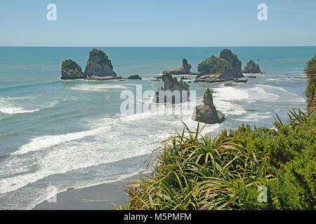 Native Bush Frames ein Strand bei Ebbe auf dem West Coast Beach, South Island, Neuseeland Stockfoto