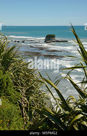 Native Bush Frames ein Strand bei Ebbe auf dem West Coast Beach, South Island, Neuseeland Stockfoto