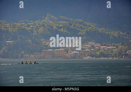 Blick auf den Comer See an einem bewölkten Tag mit Ruderer im Vordergrund im Bellagio, ein charmantes Dorf zwischen dem See und den Bergen der Alpen. Stockfoto