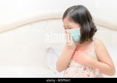 Asiatische Mädchen leiden unter Husten mit Gesichtsmaske Schutz, Virenschutzkonzept. Stockfoto