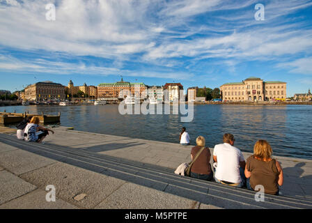 Menschen entspannend im Gamla Stan, im Hintergrund das Grand Hotel und das Nationalmuseum (rechts), Stockholm, Schweden Stockfoto