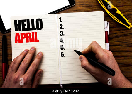 Wort, Schrift Hallo April. Geschäftskonzept für den Frühling Willkommen geschriebene Buch, Holz- Hintergrund mit Geschäftsmann, Hand, Finger schreiben auf dem Notebook. Stockfoto