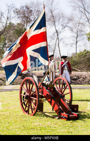 Der britische Union Jack Flagge fliegen neben einem Britischen canon während einer Wiederinkraftsetzung der Amerikanischen Revolution in Huntington Beach Kalifornien USA Stockfoto