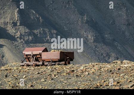 Alten, verlassenen Kohle wagen, für die Kohle Bergbau eingesetzt, Berg Hintergrund Longyear Tal, Svalbard Norwegen. Arktische Landschaft. Stockfoto