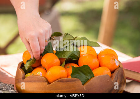 Hölzerne Schüssel von Mandarinen auf einem Tisch Stockfoto