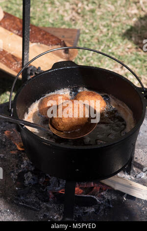 Frittieren golden braun scotch Eier draußen über dem offenen Holzfeuer in einem schweren Gusseisen Topf. Stockfoto