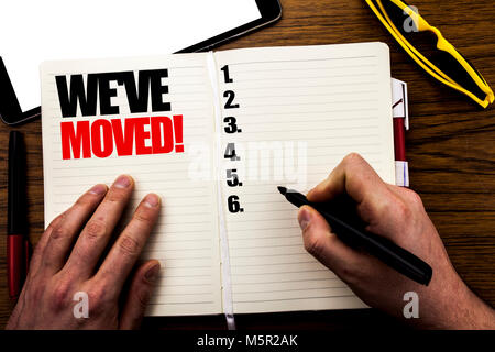 Wort, Schrift, Wir sind umgezogen. Business Konzept für Unternehmen ändern Ort geschrieben Buch, Holz- Hintergrund mit Geschäftsmann, Hand, Finger schreiben auf der Stockfoto