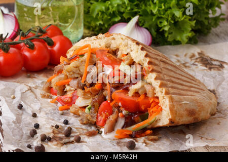 Saftige shaverma mit gehacktem Fleisch und frisches Gemüse. Still-life auf einem hölzernen Hintergrund. Stockfoto