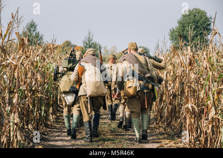 Reenactors-Männer gekleidet als russische sowjetische Rote Armee Infanterie Soldaten des zweiten Weltkriegs marschieren In Feld mit Waffe am historischen Reenactmen Maschinengewehr Stockfoto