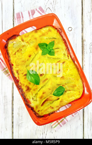 Aus Kartoffelpüree mit Fischfilets in eine brazier Kasserolle auf einem Handtuch auf einem Holzbrett Hintergrund Stockfoto