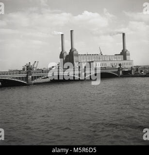 Anfang der 1950er Jahre, historische Blick von Norden auf die berühmten Gebäude, Battersea Power Station bei Nine Elms, Wandsworth Battersea, am Südufer der Themse, London, England, UK. Eine der weltweit größten Backsteinbauten, es gab einen funktionierenden Kohlekraftwerk Stromerzeugung bis 1983. In dieser Zeit, Anfang der 1950er Jahre, das Kraftwerk hatte nur drei chimeys, der vierte im Jahr 1955 aufgenommen. Stockfoto