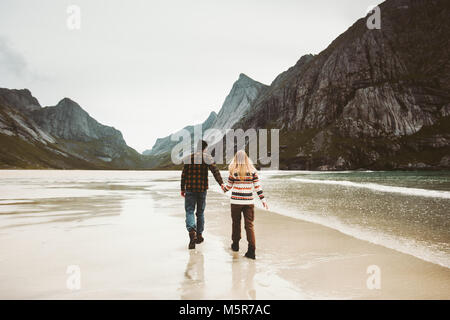 Paar in Liebe gehen, Hände auf wilden Meer Strand in Norwegen Mann und Frau zusammen Reisen Lifestyle Konzept romantische Ferien Stockfoto