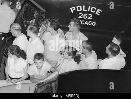 Eine Nachbarschaft versammelt sich am Tatort in Chicago, Ca. 1955. Stockfoto