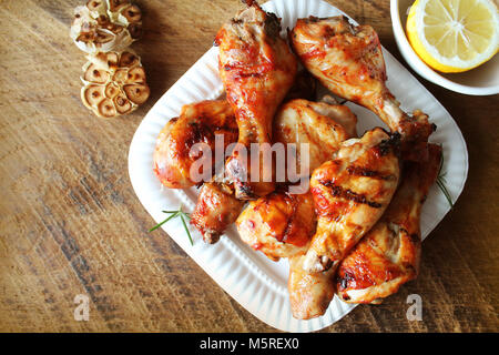 Gegrillte Hähnchenschenkel auf weiße Platte. rustikales Abendessen Hintergrund Stockfoto