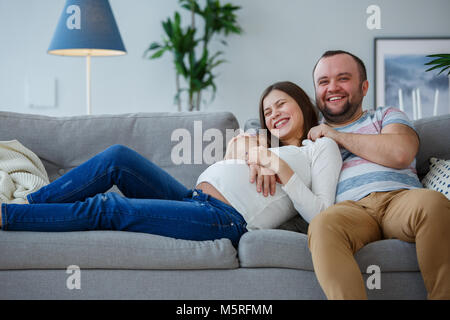 Foto von glücklich verheiratetes Paar auf grau Sofa Stockfoto