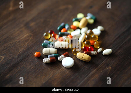 Medikamente und Tabletten auf einer hölzernen Textur Tabelle Stockfoto