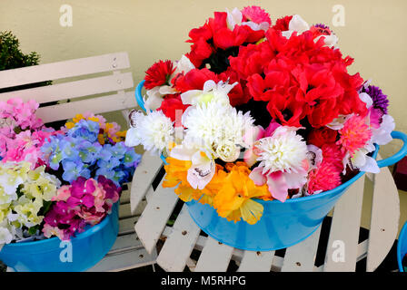 Farbenfrohe künstliche Blumen auf Anzeige außerhalb des Shops, North Norfolk, England Stockfoto