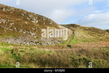 Zu Fuß durch Schälen Klippen entlang der Hadrianswall Fußweg auf einem herbstmorgen in der Nähe von Hexham, Northumberland, Großbritannien. Stockfoto