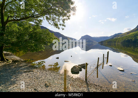 Blick über den Lake Buttermere vom Kiesstrand Ufer im englischen Lake District an einem Sommertag, UK. Stockfoto