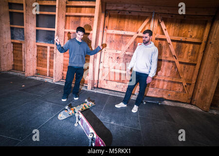 Zwei junge Skater üben mit ihren Skateboards in einen Indoor skate Hall. Stockfoto
