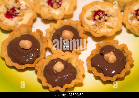 Italien Gastronomie Warenkorb Mürbteig mit orange Creme, Tropfen Erdbeermarmelade und süßen Korb mit dunkler Schokolade und Haselnuss Stockfoto