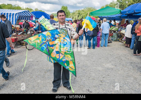 Mann Verkauf von Kites und ukrainischen Fahnen auf den Tag in der Stadt von Kossiw, Karpaten, Prykarpattia Pokuttya, Region, Ukraine Stockfoto