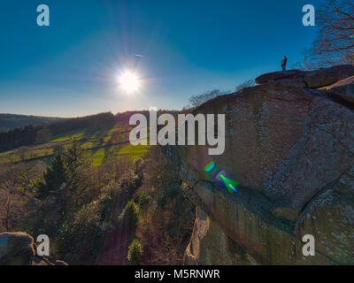 Peak District, Derbyshire, UK. 25. Februar, 2018. UK Wetter Mann bewundern Sie die kalten klaren blauen Himmel und spektakulären Blick von oben auf Cratcliffe Tor, mit einem gritstone Felswand unter ihm im Peak District National Park, Derbyshire, UK Credit: Doug Blane/Alamy leben Nachrichten Stockfoto