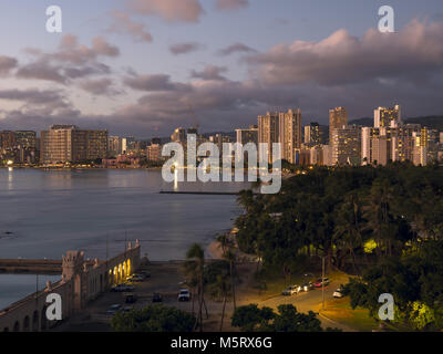 Honolulu, Hawaii, USA. 13 Dez, 2017. Eine malerische hoher Winkel Dämmerung Blick auf den Kapiolani Park und Hochhaus Hotels entlang der Küste von Waikiki. Im Vordergrund (links) ist die Schwimmhalle War Memorial, eine 1920 s Salzwasser Swimmingpool auf dem nationalen Register der historischen Plätze, aber nicht mehr im Einsatz. Credit: bayne Stanley/ZUMA Draht/Alamy leben Nachrichten Stockfoto