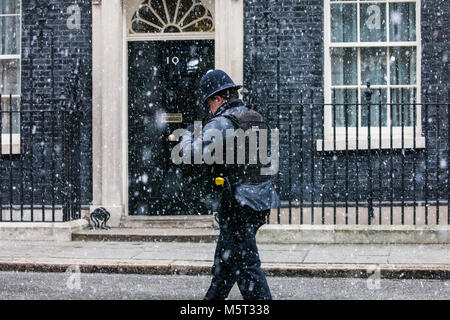 London, Großbritannien. 26. Februar, 2018. Ein Polizeioffizier Spaziergänge vor Downing Street 10 durch wirbelnden Schnee. Credit: Mark Kerrison/Alamy leben Nachrichten Stockfoto