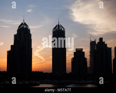 DUBAI, VAE - Februar 2018: die Silhouetten von modernen Wolkenkratzern in Sunrise Leuchten in Dubai Marina in Dubai, VAE. Stockfoto