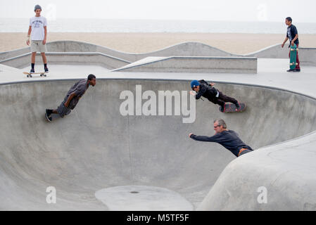 Skateboarder Tricks ausführen im Pool an der Skatepark von Venice Beach, Santa Monica, Kalifornien, Stockfoto