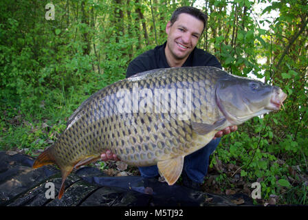 Karpfen angeln. Lucky Fisherman Holding eine riesige Karpfen Stockfoto