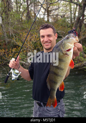 Angler mit einem Barsch, Köder Angeln, Fischfang, catch und Release Stockfoto