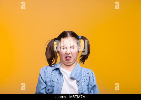 Mädchen im Studio machen ein angewidertes Gesicht mit geschlossenen Augen Stockfoto