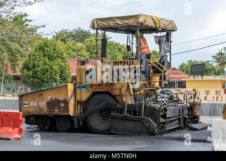 PENANG, MALAYSIA, 10.November 2017, den Asphalt Maschine setzt eine neue Oberfläche - Schicht auf der Straße. Eine belagserneuerung Bau von Straßen. Stockfoto