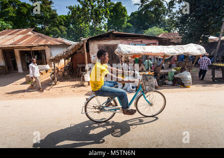 Stone Town, Sansibar - Februar 8, 2017: Junge Reiten Fahrrad entlang der Straße. Stockfoto