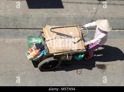 SAIGON, VIETNAM, 17.12.2017, Sammlung von verwertbaren Abfällen in den Straßen von Ho Chi Minh Stadt. Vietnamesische Frau treibt einen Wagen voller Taschen, Saigon Stockfoto