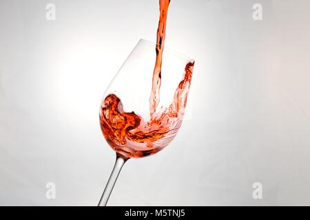 Rotwein wird in ein Glas gegossen Stockfoto