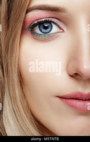 Closeup schoss der weiblichen Hälfte Gesicht mit Rosa und Grün blaue Augen Make-up Stockfoto
