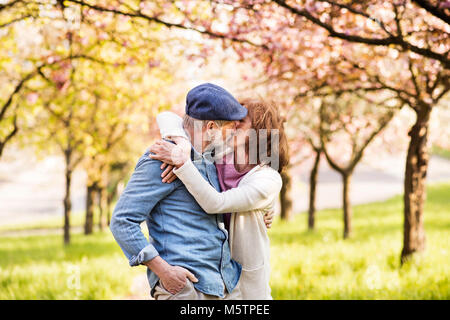 Senior Paar in Liebe außerhalb im Frühjahr die Natur zu küssen. Stockfoto