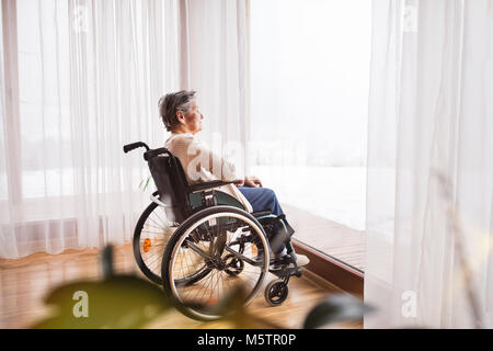 Ältere Frau im Rollstuhl zu Hause. Stockfoto