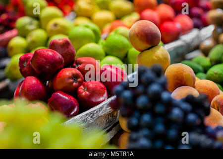 Stapel der Früchte (rote und grüne Äpfel, Weintrauben, Pfirsiche usw.) gesehen an den Obstmarkt von Paloquemao in Bogotá, Kolumbien angeordnet. Stockfoto