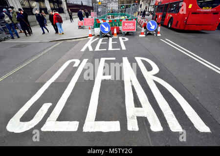 London, England, UK. "Abstand halten" auf der Straße vor den Häusern des Parlaments gestrichen während der Bauarbeiten Stockfoto