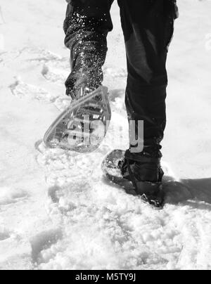 Man läuft mit Schneeschuhen in den Bergen mit Schwarzweiß-Effekt Stockfoto